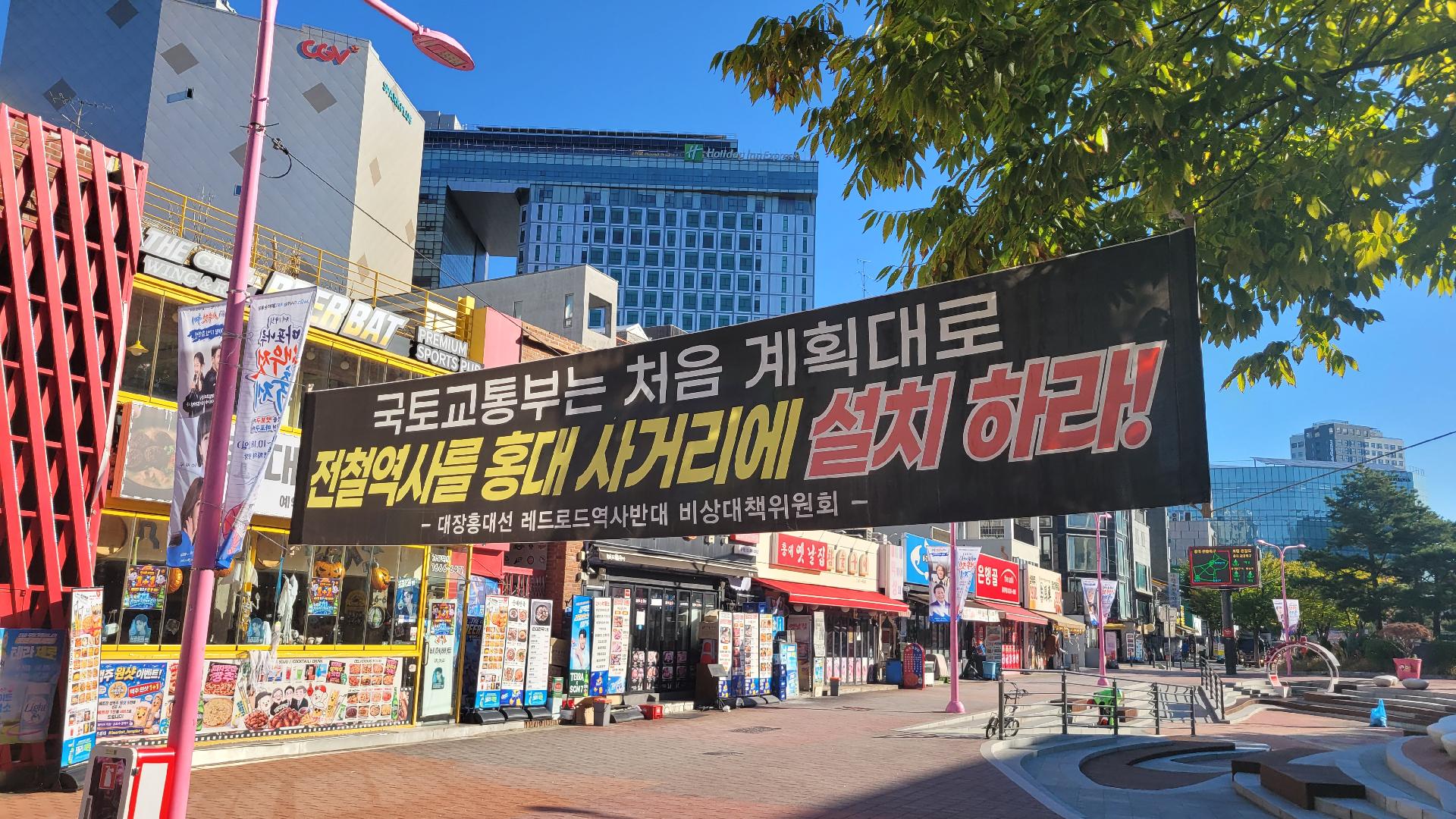 홍대 레드로드 일대에 걸린 111정거장 홍대사거리 위치조정 요구 현수막